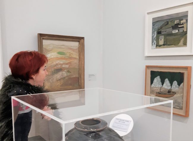 Karyn Watt, the Trust's Chair at Tate St Ives earlier this year, admiring Barns-Graham's Island Sheds, St Ives No.1, 1940, presented by the artist to Tate in 1999., alongside works by Alfred Wallis, Adrian Stokes and Benard Leach.