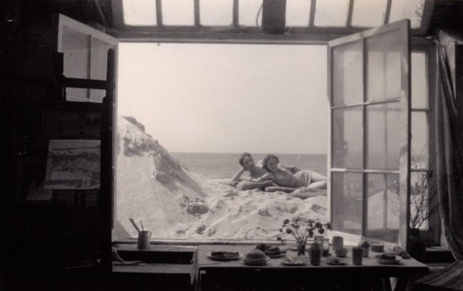 Photograph of WBG and friend, possibly Robert Wagner, on Porthmeor beach taken through her studio window © Wilhelmina Barns-Graham Trust